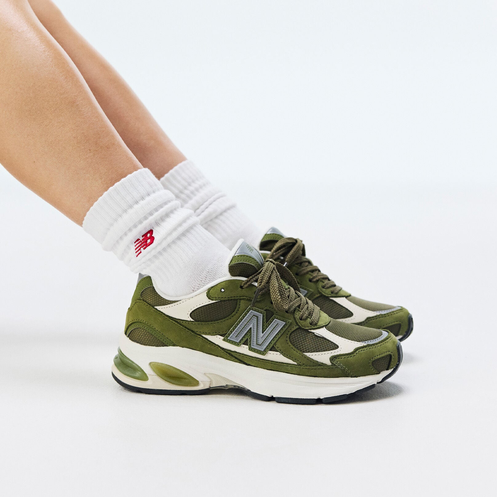 Knee down of person wearing green ABZORB 2010 sneakers